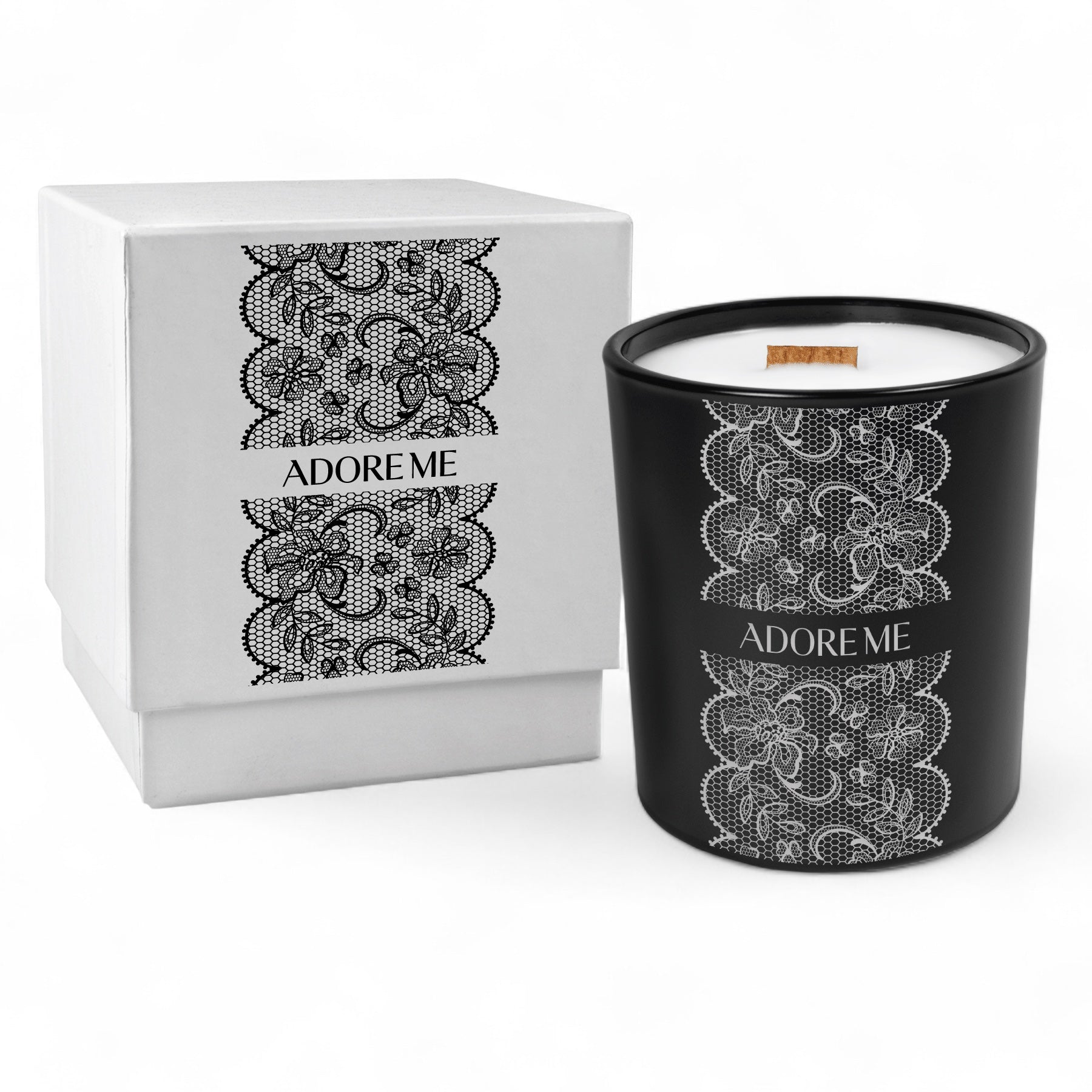 A black glass candle with a wooden wick, engraved with a black lace pattern next to a white box, with the same pattern printed in black.