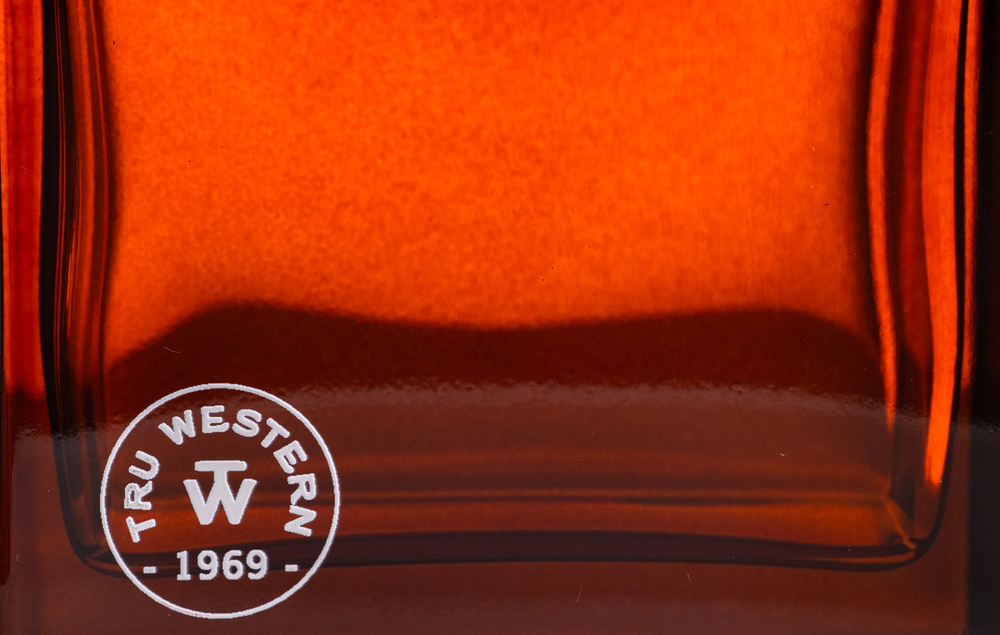 Close-up of amber glass printed with a round seal logo