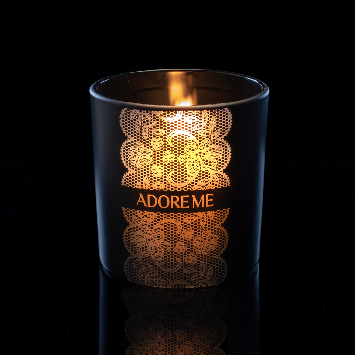 Matte Black 14 oz. Luxury Engraved Candle lit, shown on a black background.