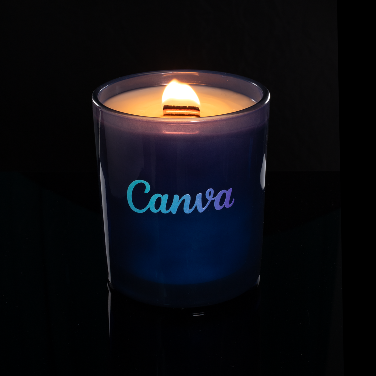 Blue 14 oz. Luxury Printed Candle lit, shown on a black background.