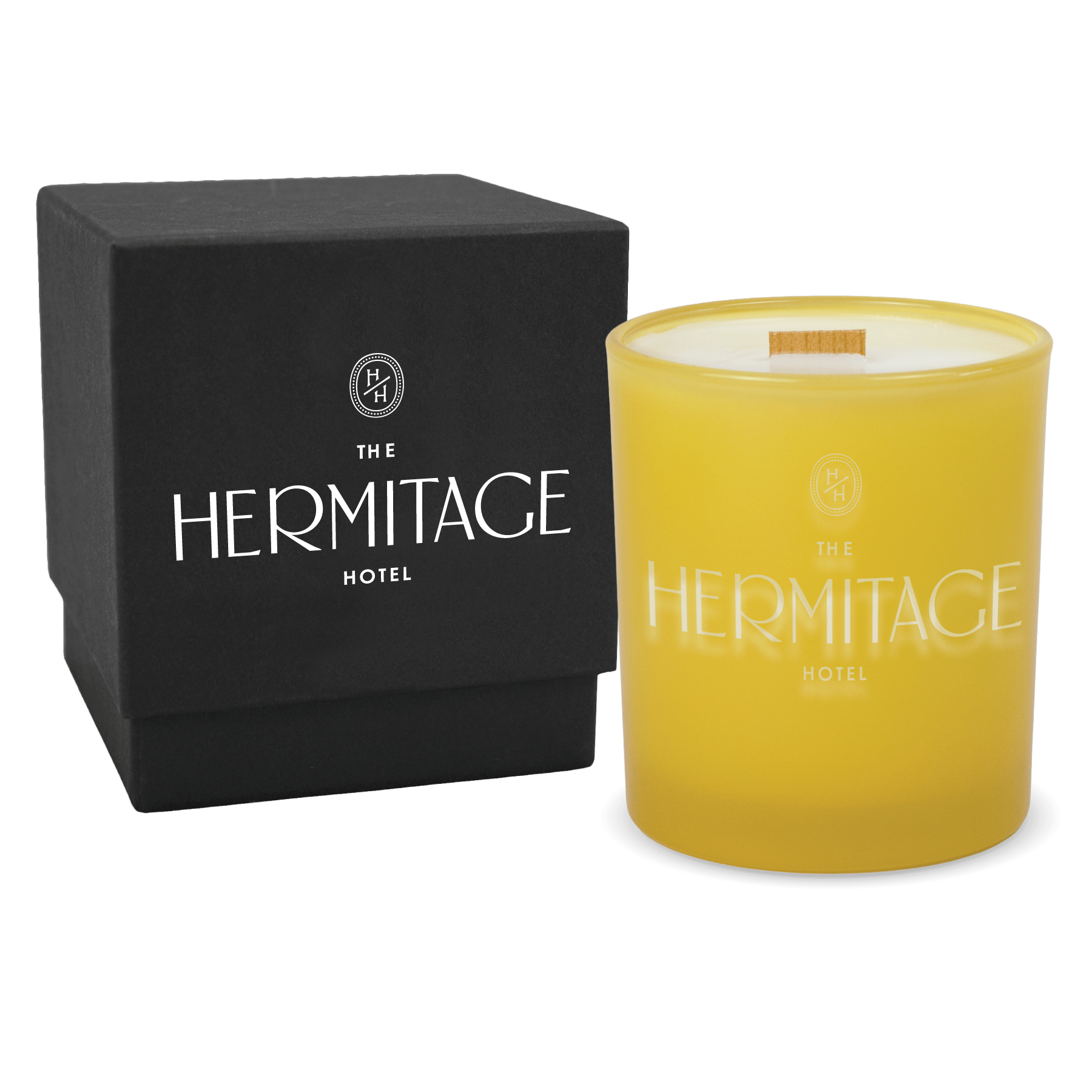 Yellow colored-glass 14 oz candle beside a matte black gift box.