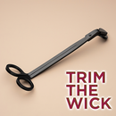 A black pair of wick trimmers from Custom Candles L.A. on a beige background with the text "Trim the wick" on the bottom right corner.