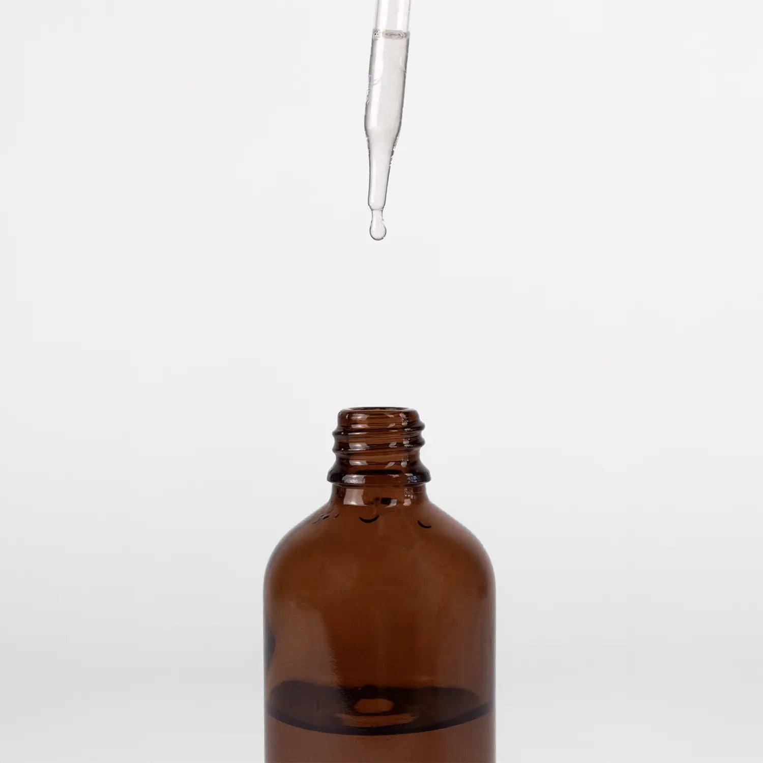 Brown glass dropper bottle with a dropper on a white background