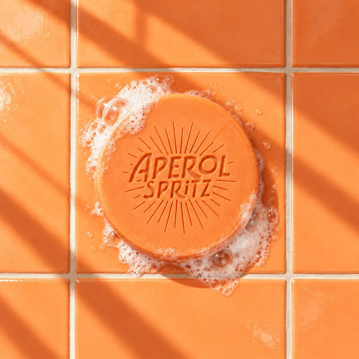 Orange round bar soap laser engraved with a brand logo, 3.6 oz, with soap bubbles