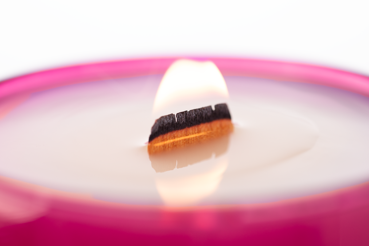 Pink 14 oz. Luxury Engraved Candle burning, close-up of the flame and wax pool.