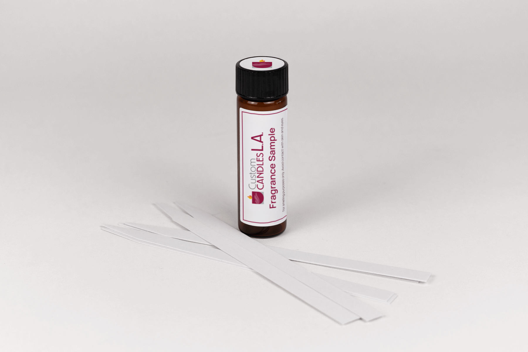 Fragrance sample bottle with sticks on a white background