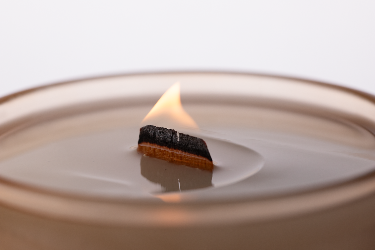Sand 14 oz. Luxury Engraved Candle burning, close-up of the flame and wax pool.