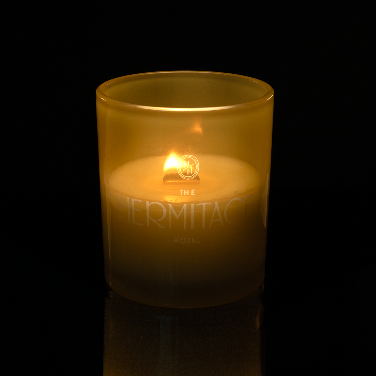 Yellow 14 oz. Luxury Engraved Candle lit, shown on a black background.