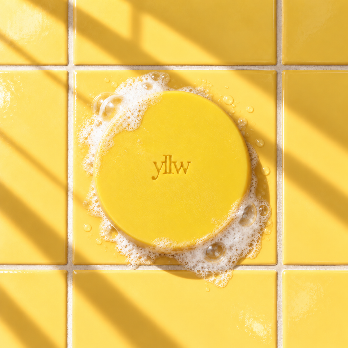 Yellow round bar soap laser engraved with a brand logo, 3.6 oz, with soap bubbles