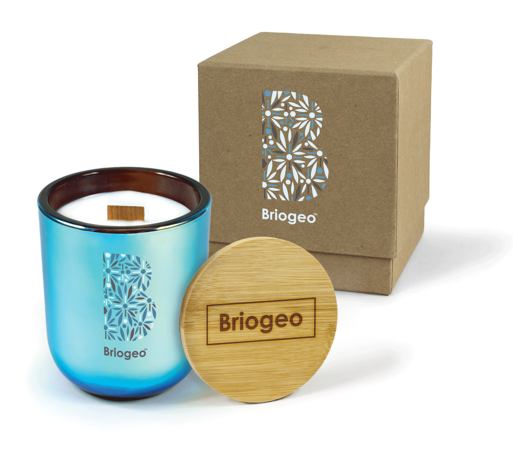 A 12 oz Luxe Custom Candle in the color “Euphoria” which is a metallic blue from Custom Candles LA. The candle features a wood wick and blue, white, and gray 4-color “Briogeo” and abstract patterned B icon printed on the front of the glass. Leaning against the side of the candle is a bamboo candle lid engraved with the “Briogeo” logo. In the background, there is a kraft 2-piece box printed with the same abstract B on the candle and a white “Briogeo”.