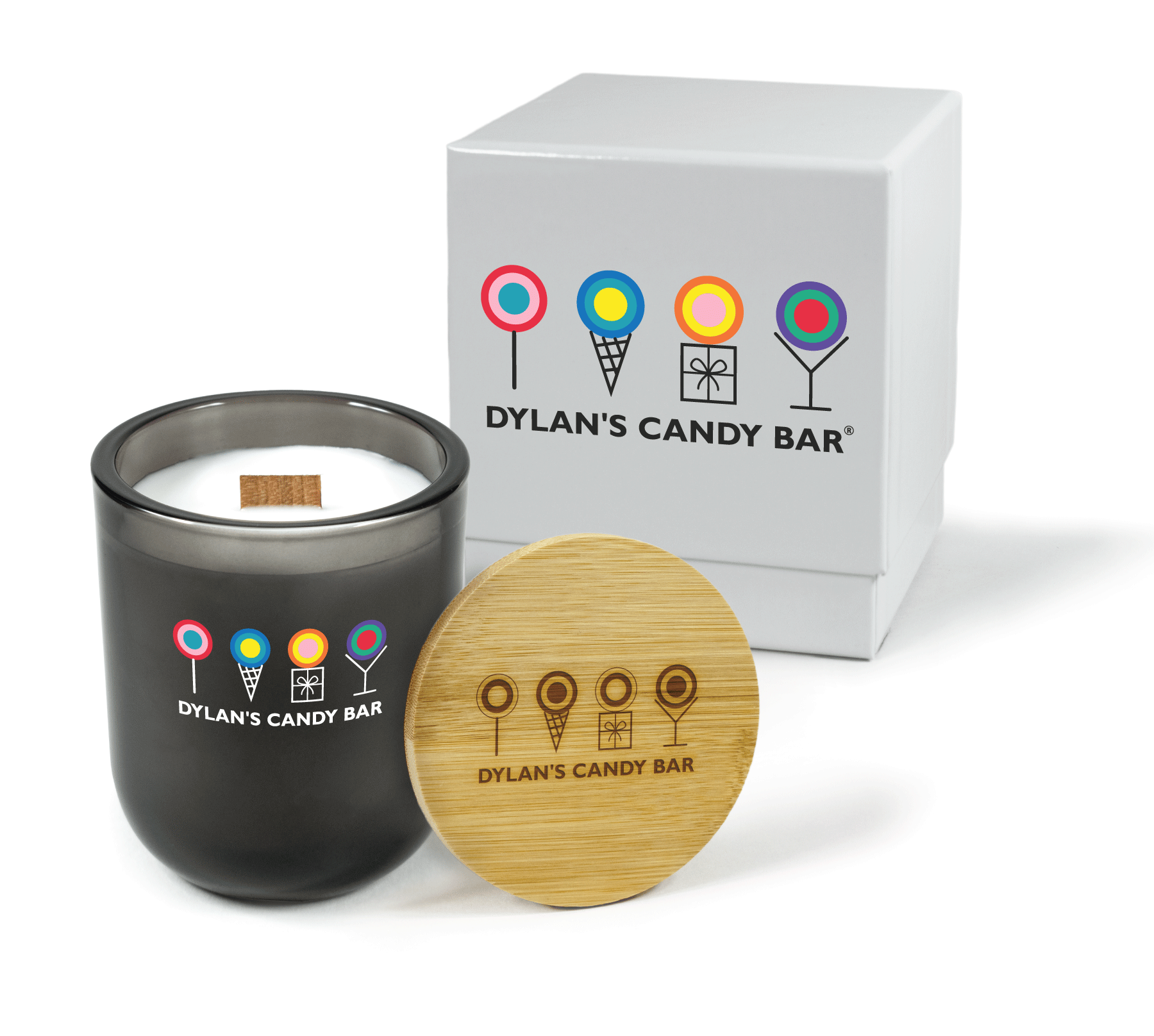 A 12 oz Luxe Custom Candle in the color “Nightfall” which is a smoke gray from Custom Candles LA. The candle features a wood wick and “Dylan’s Candy Bar” logo with 4-color printed multi-colored candy icons above on the front of the glass. Leaning against the side of the candle is a bamboo candle lid engraved with the “Dylan’s Candy Bar” logo. In the background, there is a white 2-piece box 4-color printed with a black and colorful icons “Dylan’s Candy Bar” logo.