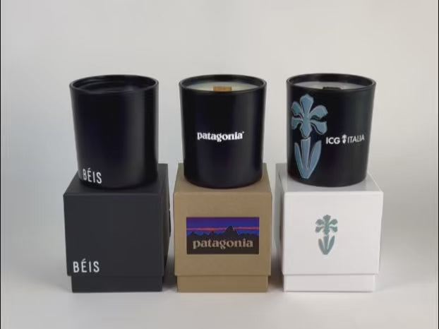 Load video: video showcase of candle lighting of 3 black 14 oz candles on top of their respective gift box, all in a row