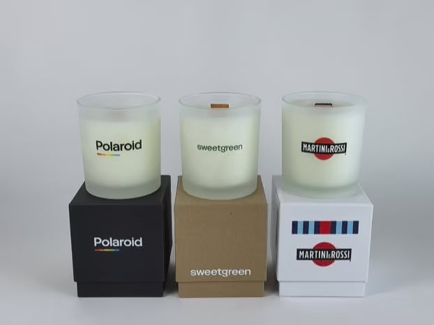 Load video: video showcase of candle lighting of 3 frosted 14 oz candles on top of their respective gift box, all in a row