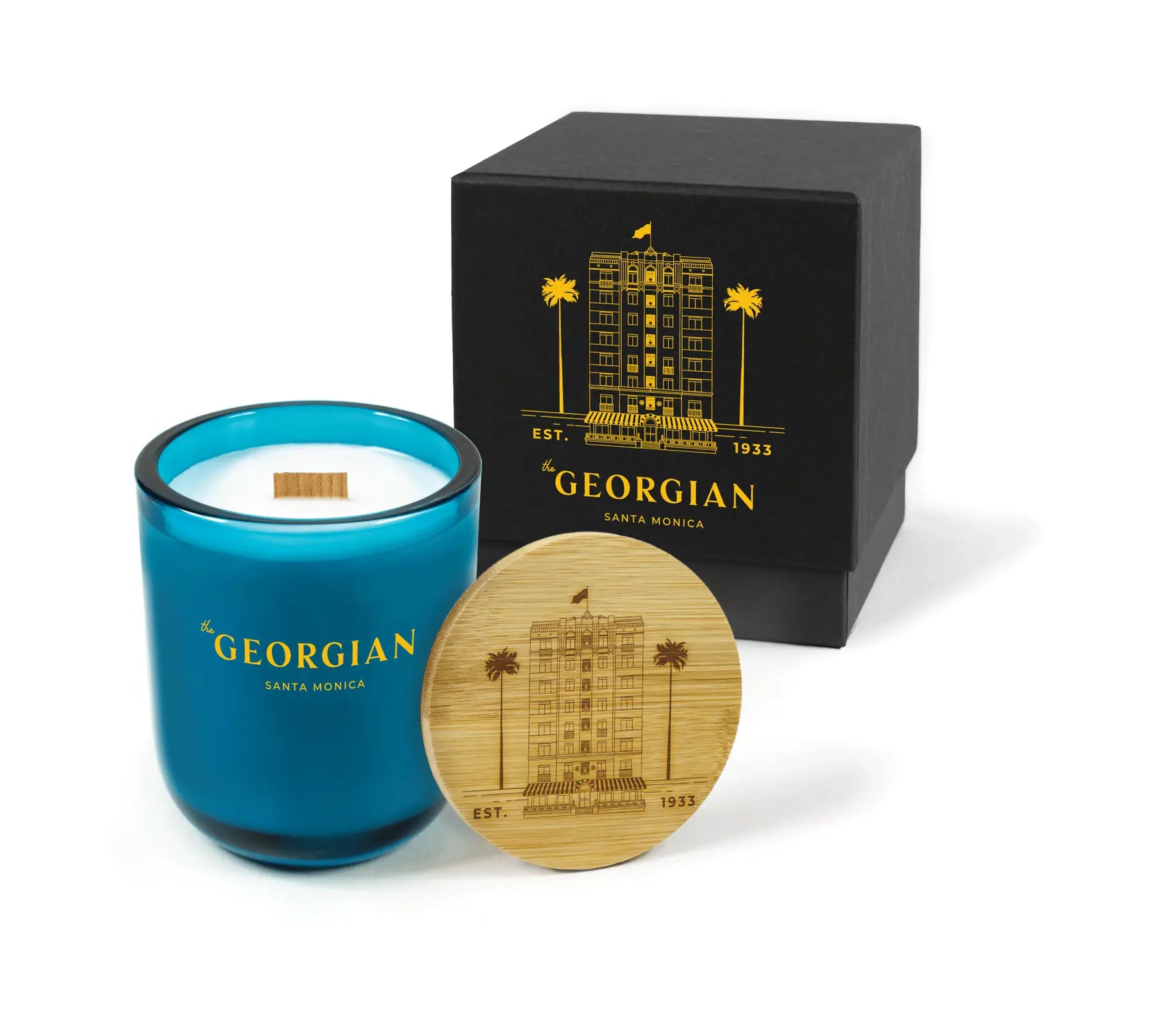 Blue candle with wooden lid and black box on a white background
