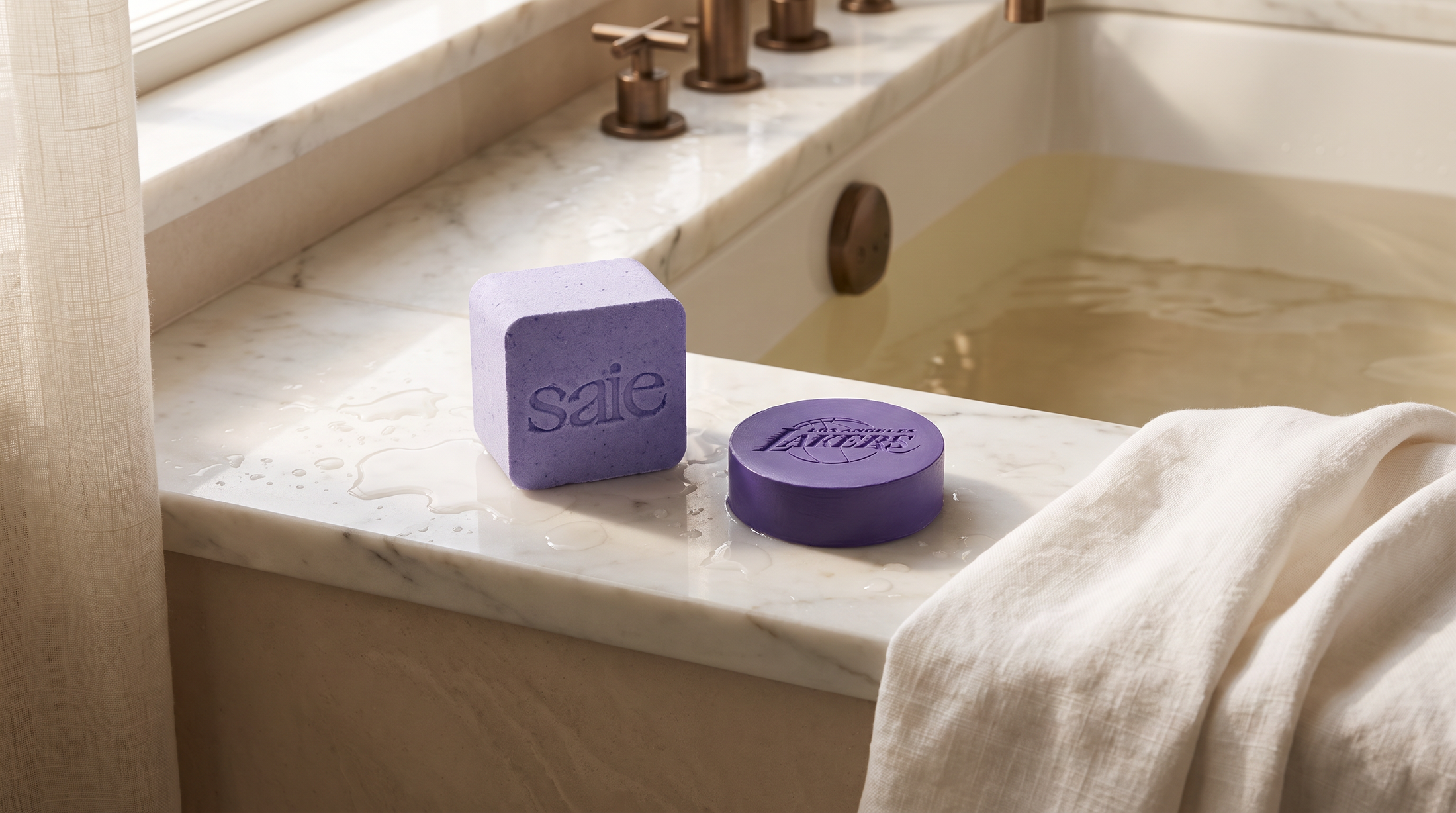Editorial luxury photograph of a branded bath bomb and bar soap on marble