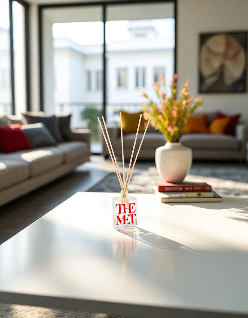 Decorative diffuser with 'The Met' branding on a coffee table in a living room.