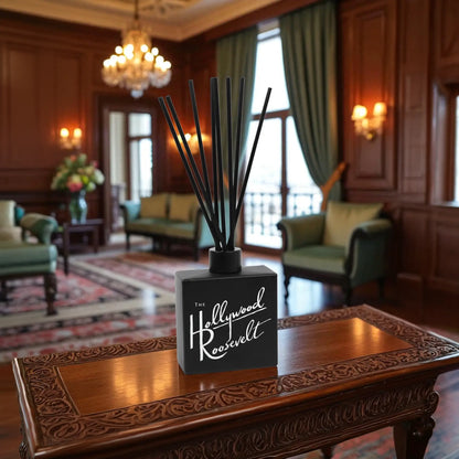 Clear 8oz Reed Diffuser with sticks on a wooden table in a luxurious room.