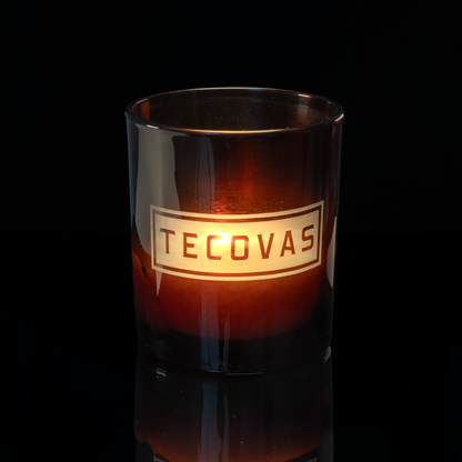 Glossy Amber 14 oz. Luxury Engraved Candle lit, shown on a black background.