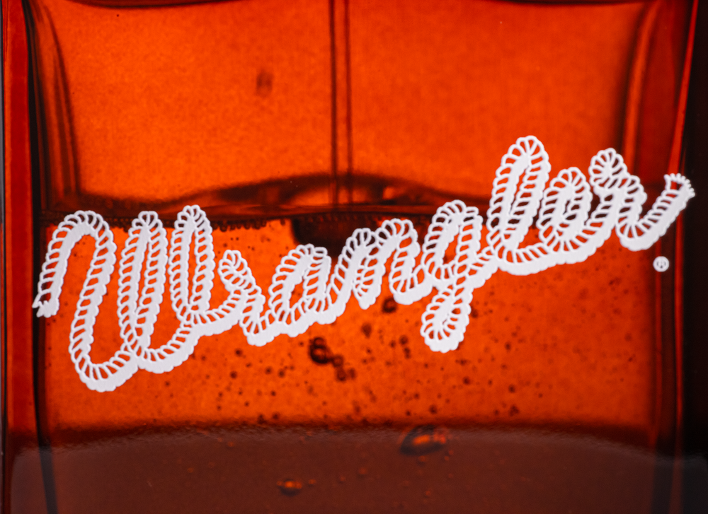 Close-up of amber glass with a neon-style script logo glowing