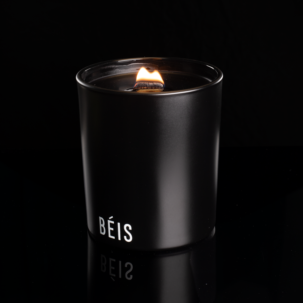 Matte Black 14 oz. Luxury Printed Candle lit, shown on a black background.