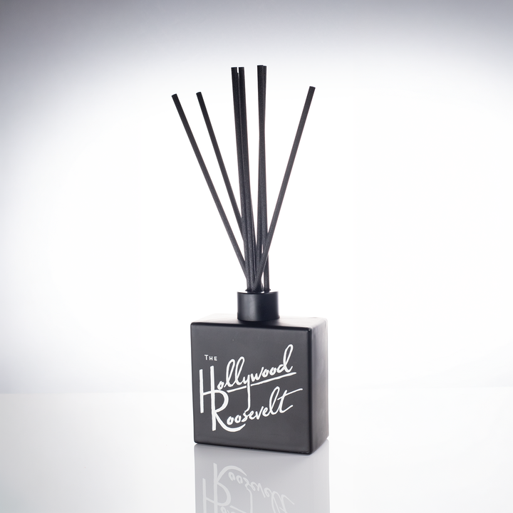 Black glass 8 oz reed diffuser with a white script logo and black reeds