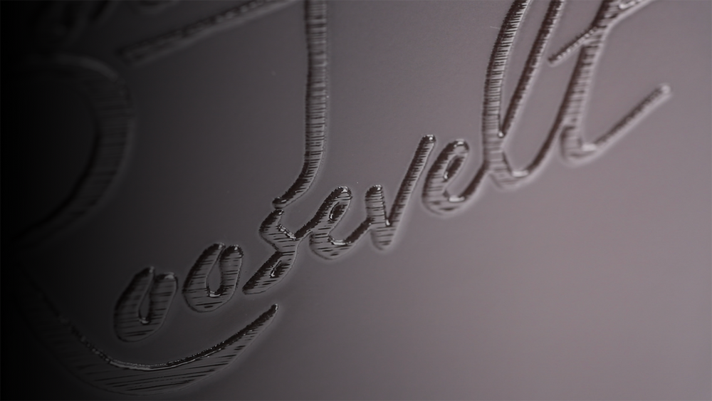 Close-up of a black-on-black embossed script logo