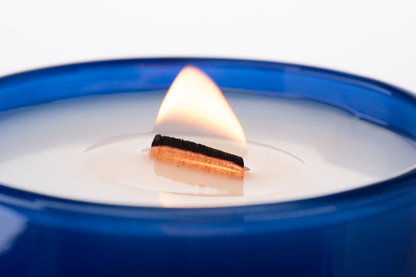 Blue 14 oz. Luxury Engraved Candle burning, close-up of the flame and wax pool.