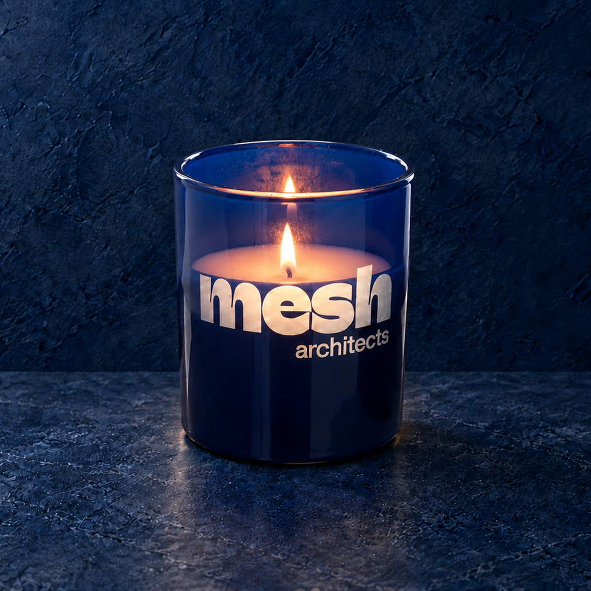 Blue 9 oz. Classic Engraved Candle with a custom engraved logo, lit.