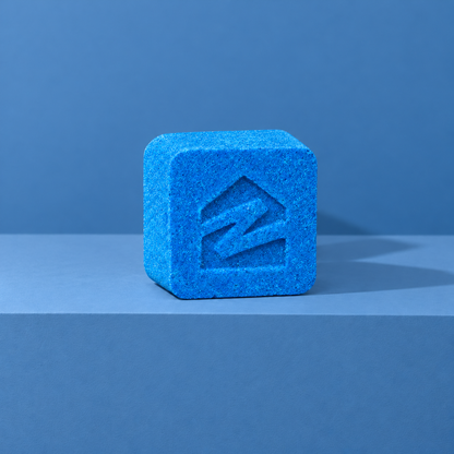 Blue custom bath bomb with a debossed brand logo on a blue backdrop, no foam