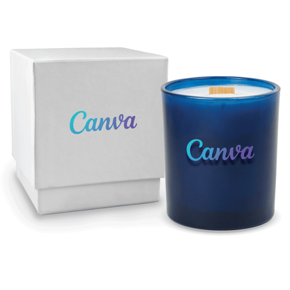 Blue colored-glass 14 oz candle beside a glossy white gift box.