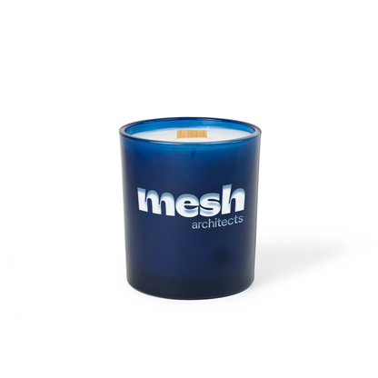 Blue colored-glass 14 oz candle with an engraved brand logo, shown on its own.