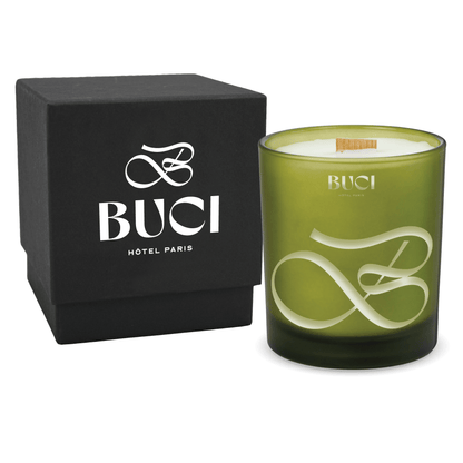 Green colored-glass 14 oz candle beside a matte black gift box.
