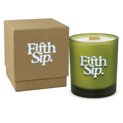 Green colored-glass 14 oz candle beside a kraft gift box.