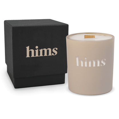 Nude 14 oz colored glass engraved logo candle beside a matte black gift box on a white background.