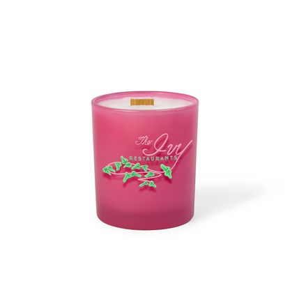 Pink colored-glass 14 oz candle with a printed brand logo, shown on its own.