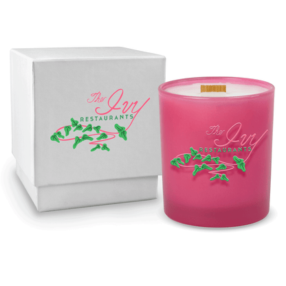 Pink colored-glass 14 oz candle beside a glossy white gift box.