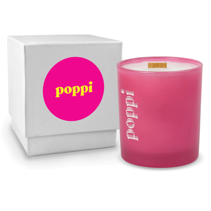 Pink colored-glass 14 oz candle beside a glossy white gift box.