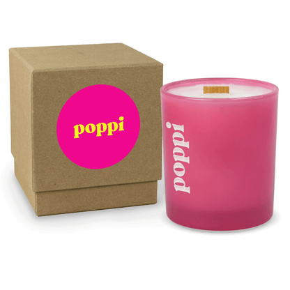 Pink 14 oz colored glass engraved logo candle beside a kraft gift box on a white background.