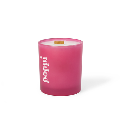 Pink colored-glass 14 oz candle with an engraved brand logo, shown on its own.