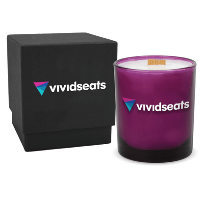 Purple colored-glass 14 oz candle beside a matte black gift box.