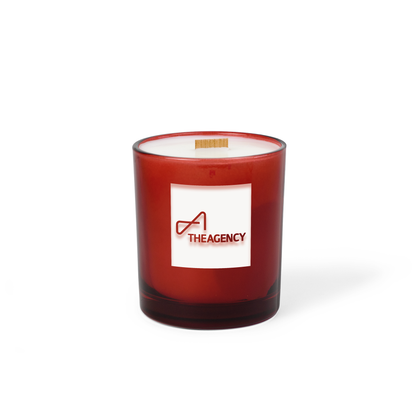 Red colored-glass 14 oz candle with an engraved brand logo, shown on its own.