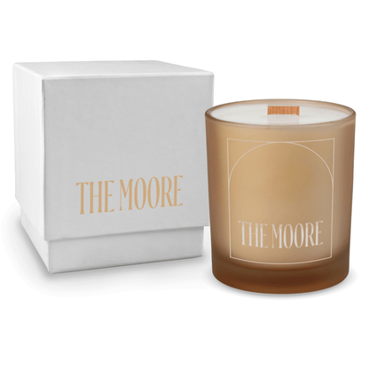 Sand 14 oz colored glass engraved logo candle beside a glossy white gift box on a white background.