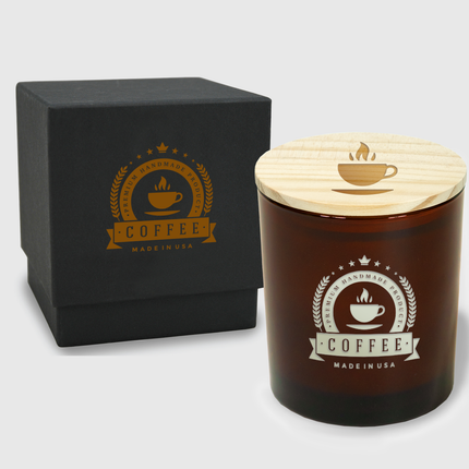 A 14 oz Deluxe "Design Your Own" Candle in an amber glass vessel from Custom Candles LA. The candle features an etched logo from a coffee company on the glass vessel and a wooden lid engraved with a hot cup of coffee. Behind the candle is a 2 piece black box with a the same imprinted coffee logo in a burnt orange color.