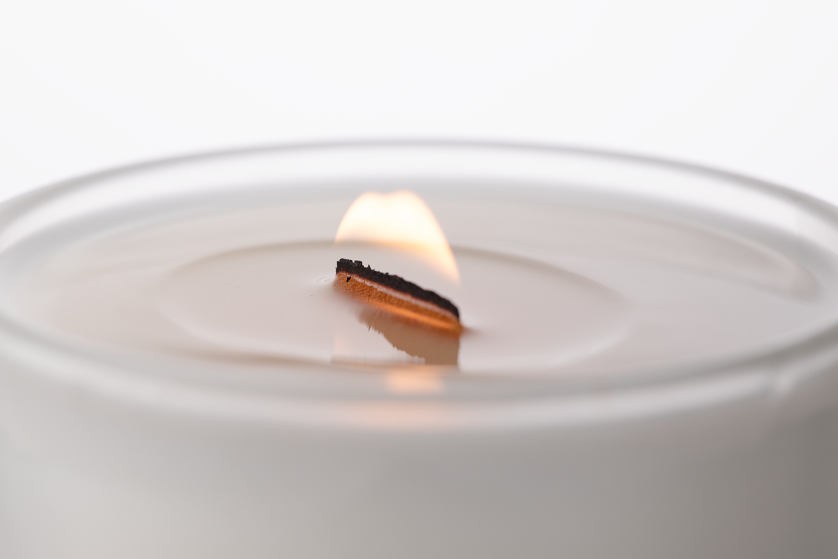 Matte White 14 oz. Luxury Printed Candle burning, close-up of the flame and wax pool.