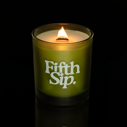 Green 14 oz. Luxury Printed Candle lit, shown on a black background.