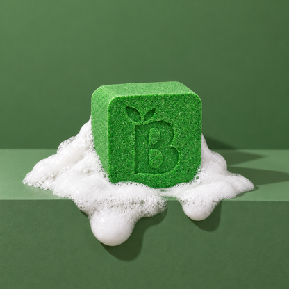 Green custom bath bomb with a debossed brand logo on a green backdrop, resting in white foam