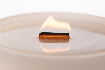 Nude 14 oz. Luxury Engraved Candle burning, close-up of the flame and wax pool.