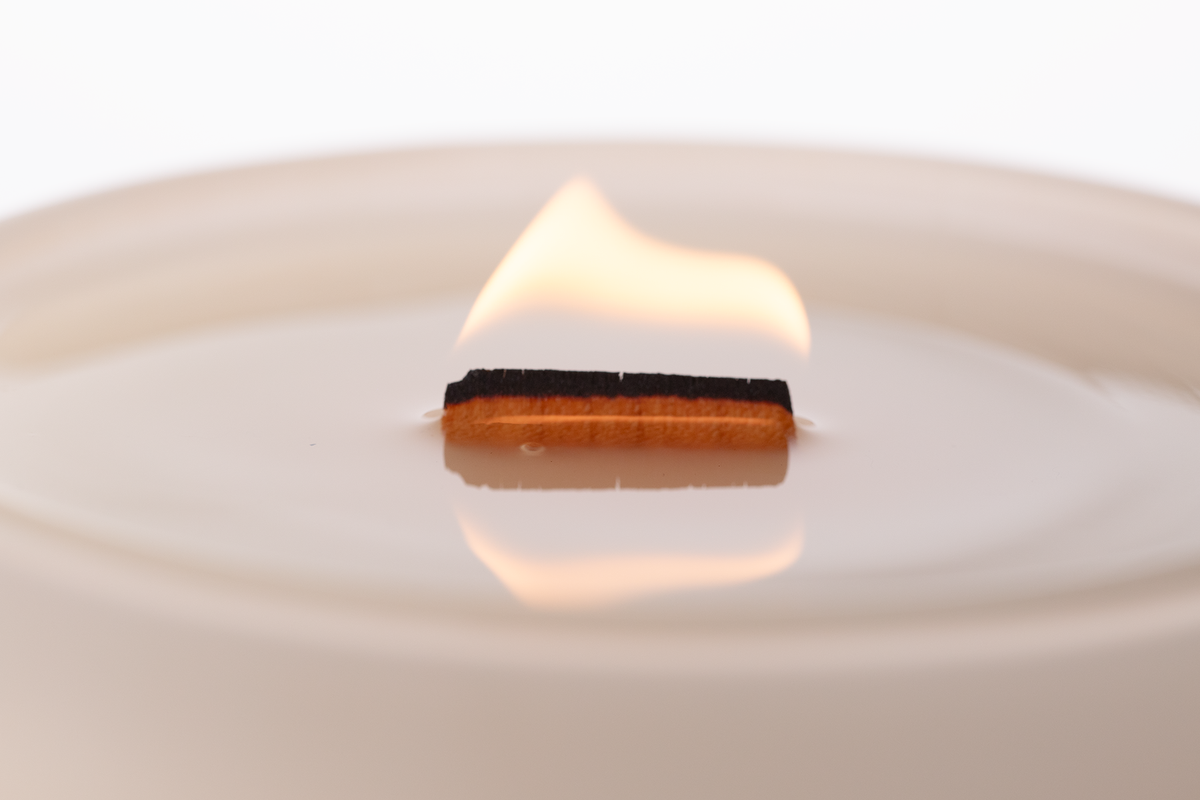 Nude 14 oz. Luxury Printed Candle burning, close-up of the flame and wax pool.
