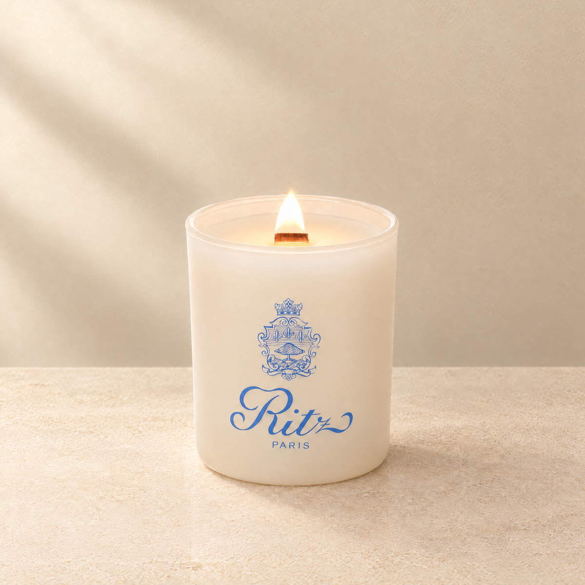 Ivory 14 oz. Luxury Printed Candle lit with a printed custom logo, shown on a matching ivory background.