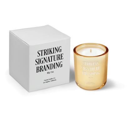 Glimmering gold 3 oz Mini Signature candle, engraved, shown beside its gift box.